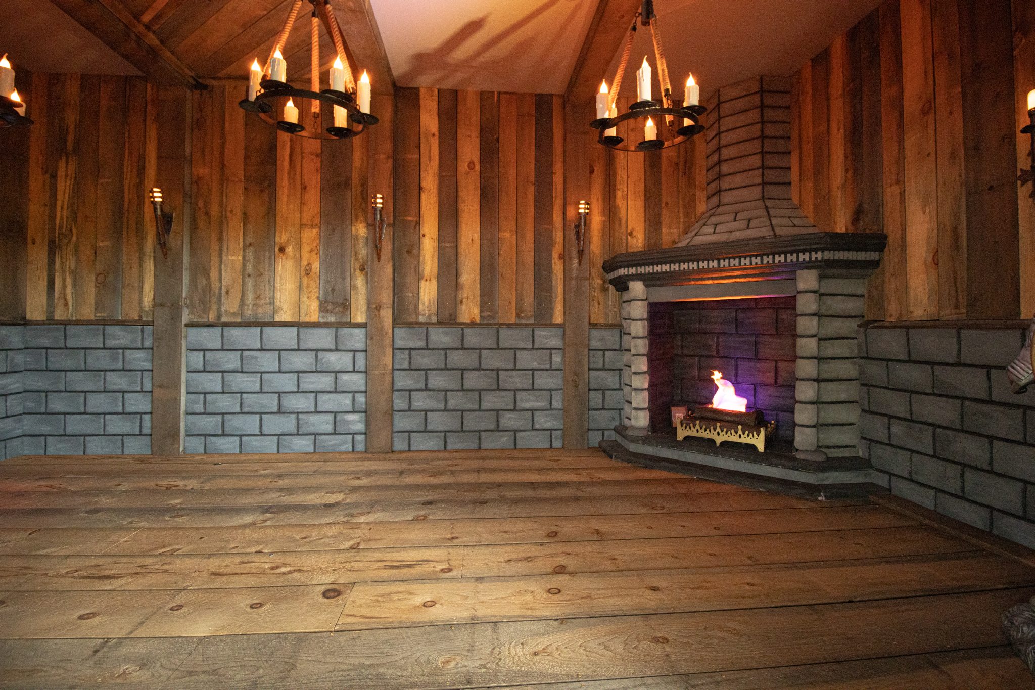 A stone and timber room with iron chandeliers and a fireplace, one of the treasure hunt's hidden rooms