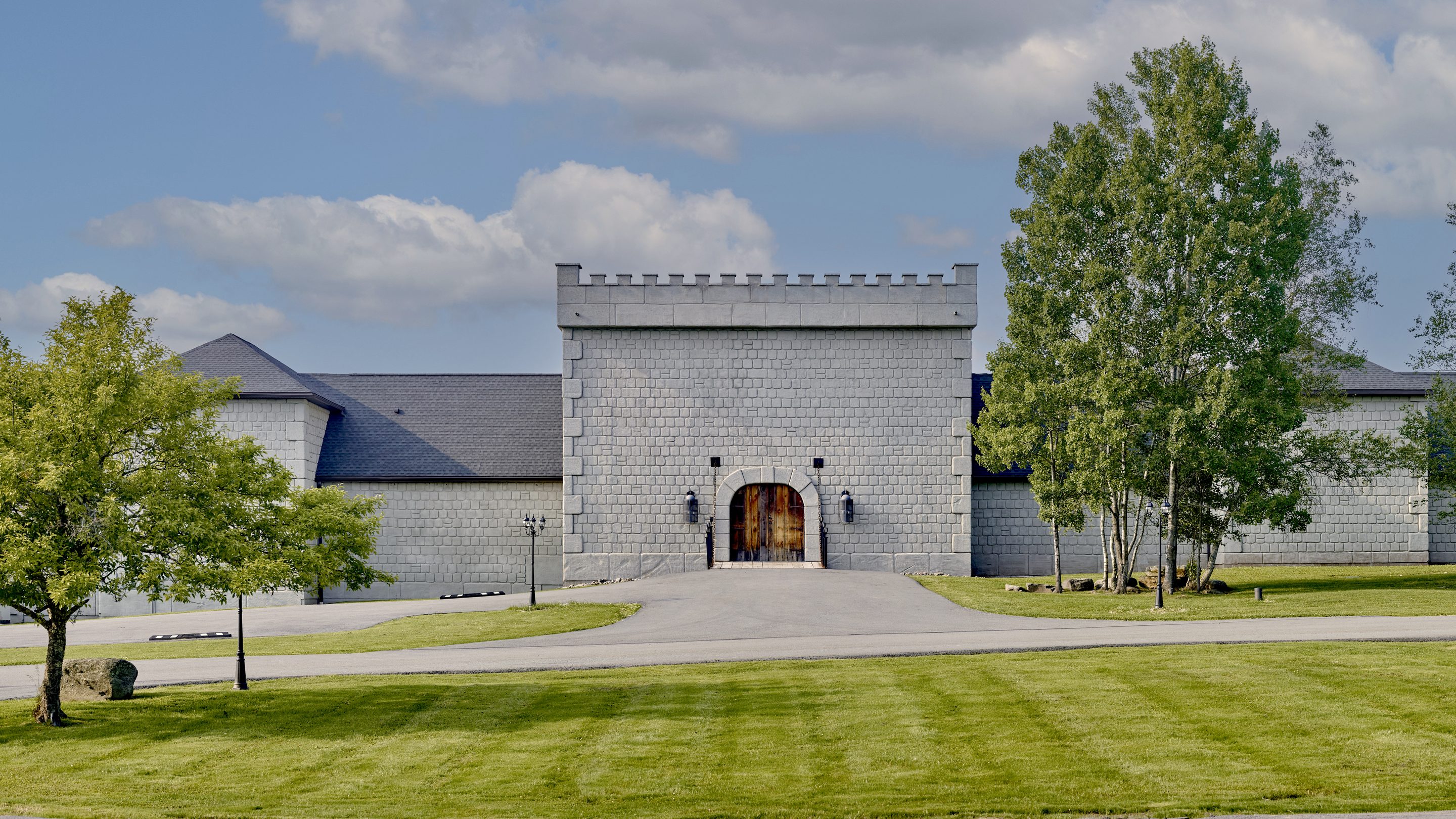 The Castle from the drive, its gatehouse and battlements above a mown lawn
