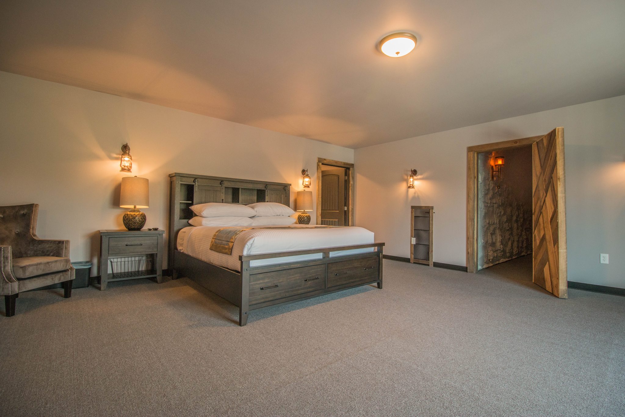Tower Suite 2: a king bed, armchairs and an arched timber door