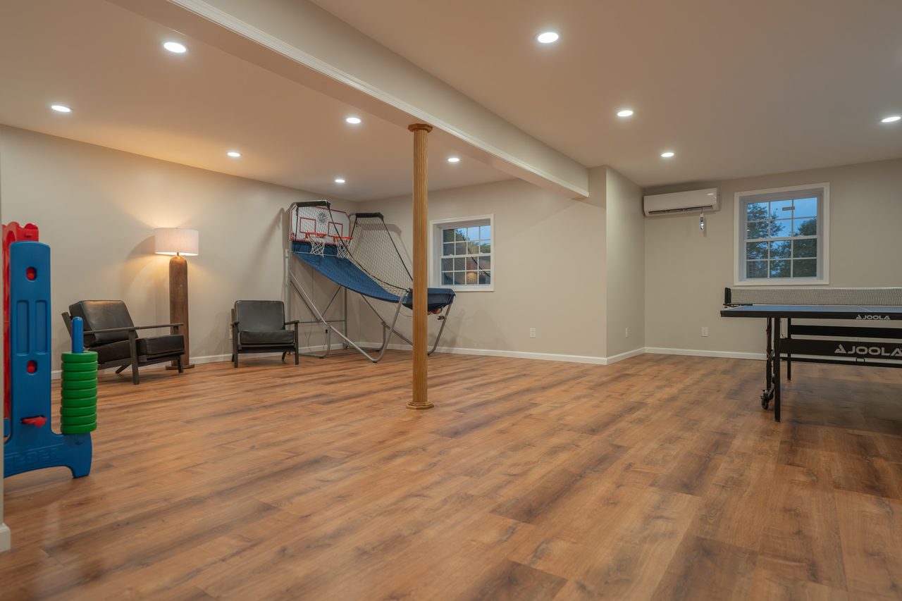 The games room from the other end, the ping pong table beyond a post and windows along the far wall