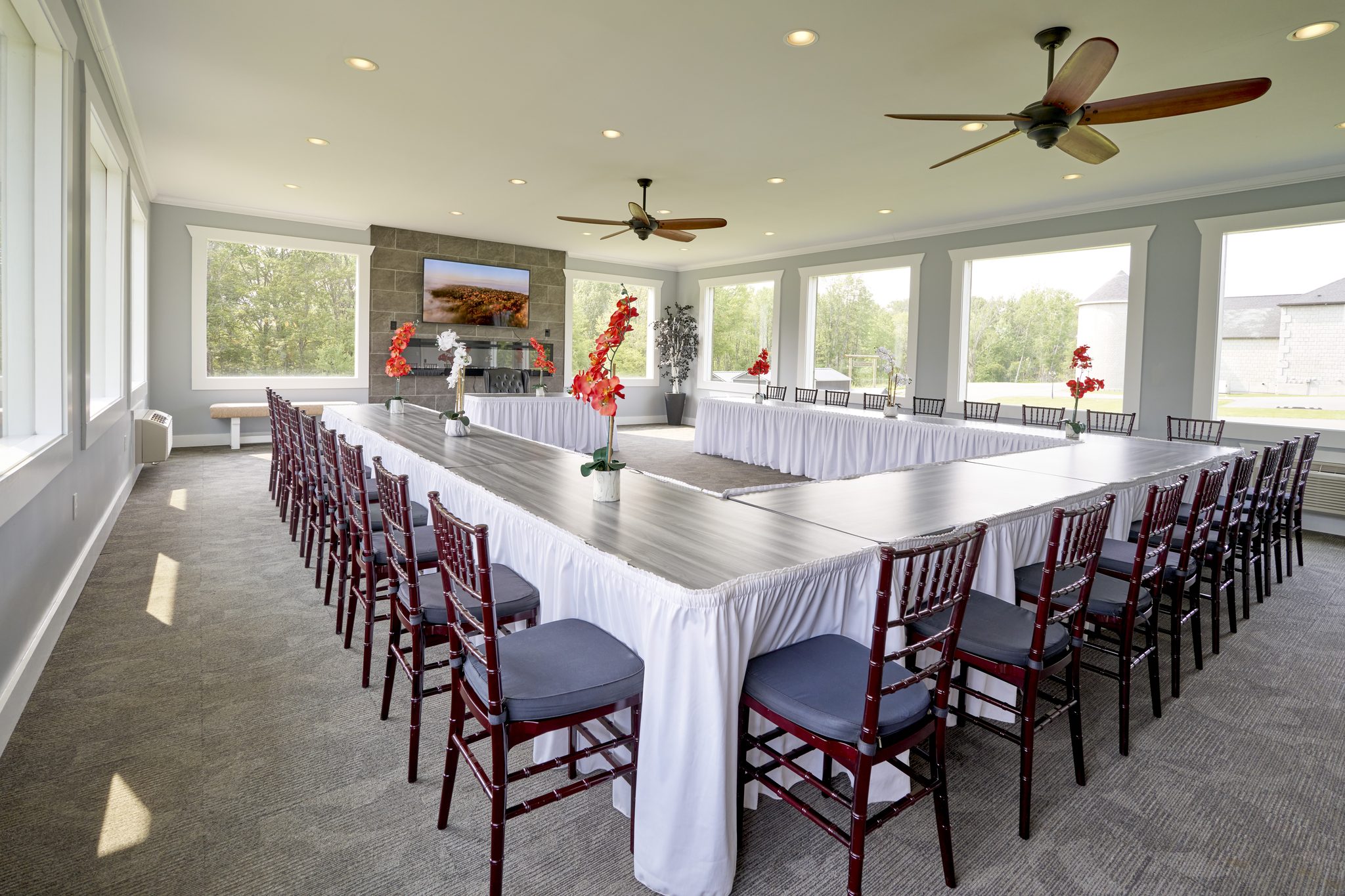 The conference room laid out as a hollow square with white cloths and a screen at the far end