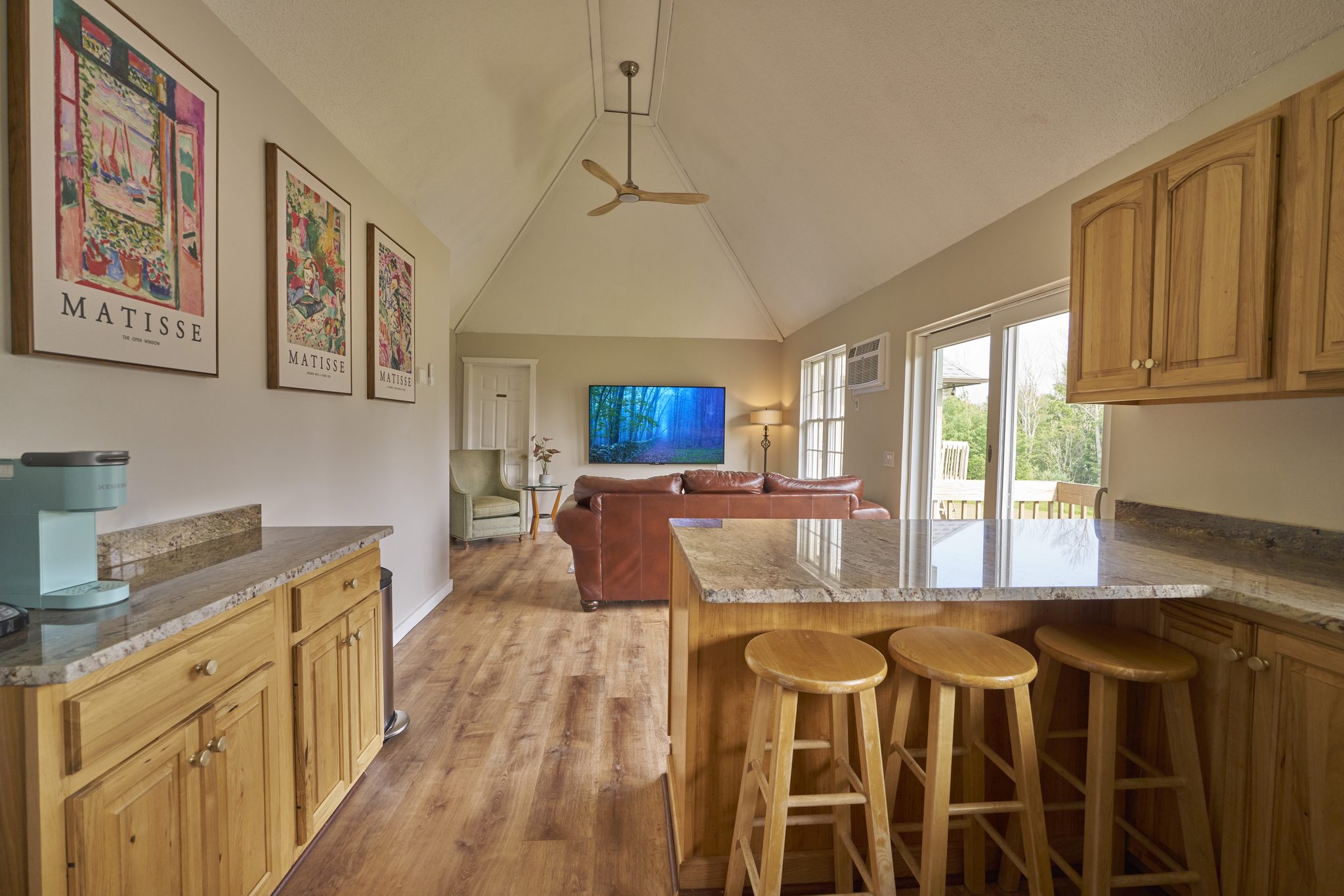 A second kitchen with a breakfast bar opening onto a sitting room with a television